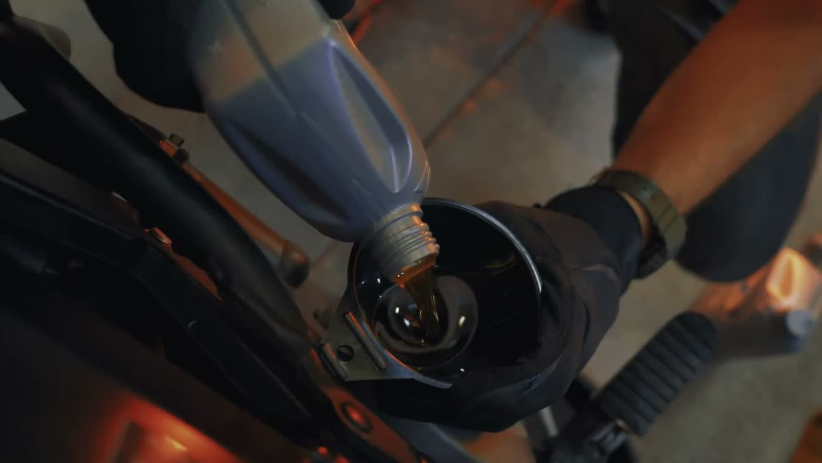 A mechanic in gloves working in an open engine bay