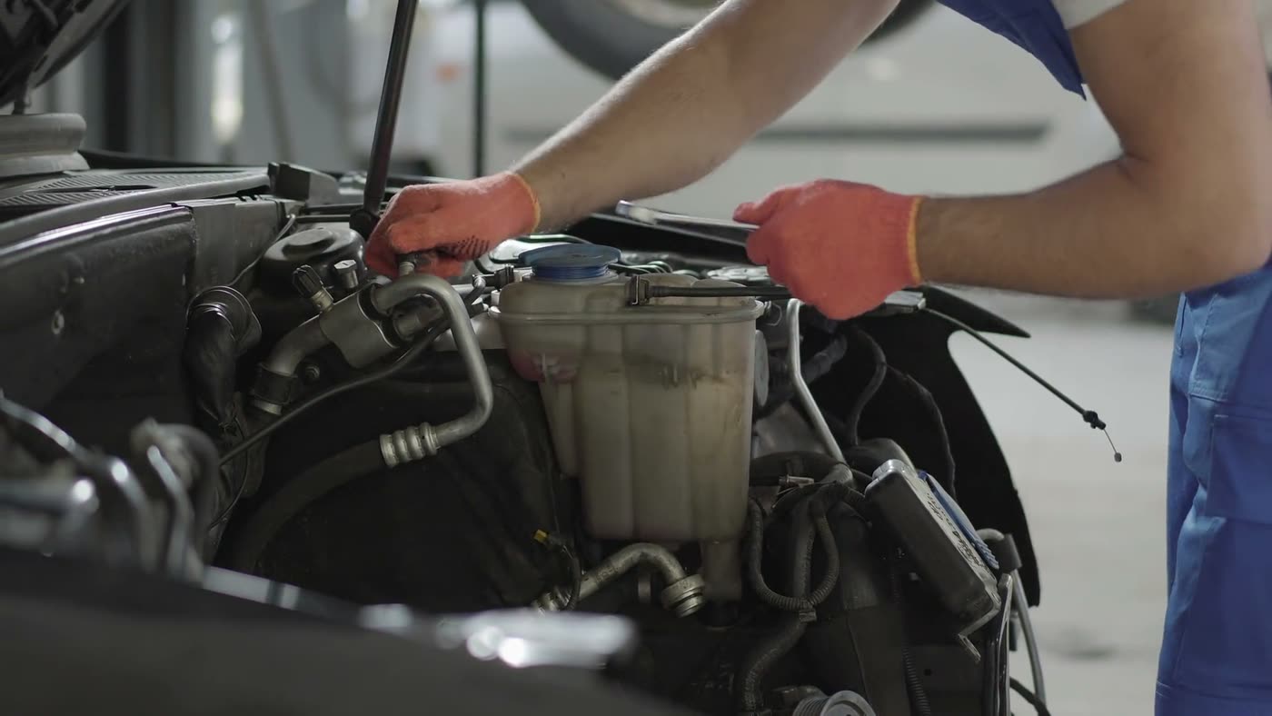 A mechanic working underneath a car raised on a lift
